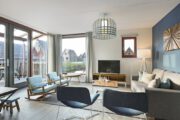 Lichte woonkamer met zithoek met fauteuils, schommelstoel en beige bank in vakantiehuis van Landal