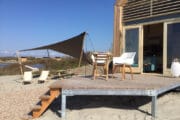 Tiny house op het strand met terras en ligstoelen
