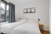 Slaapkamer met opgemaakt bed, met wit beddengoed