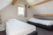 Slaapkamer met twee aparte bedden in het vakantiehuis