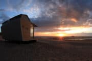 Strandhuisje bij zonsondergang