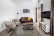 Woonkamer met bruine zitbank in een vakantiehuis in Zeeland