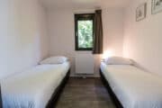 Slaapkamer met twee eenpersoonsbedden in een wellness lodge