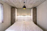 Slaapkamer met tweepersoonsbed en wit beddengoed