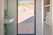 Badkamer met groot raam en zicht op de duinen
