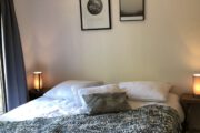 Opgemaakt bed met sprei en kussens in het vakantiehuis