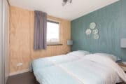 Slaapkamer met blauwgrijze wand met borden aan de wand