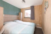 Moderne slaapkamer met houten wanden en een tweepersoons bed