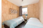Slaapkamer met houten wanden en losse bedden