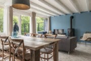 Woonkamer met eettafel, zithoek en houtkachel in het vakantiehuis van Dutchen op Ameland