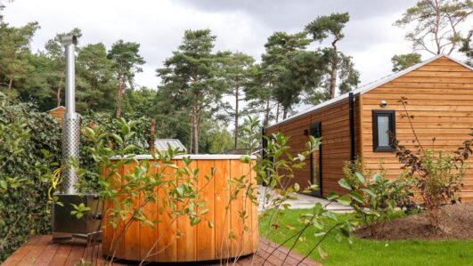 Houten huisje met hot tub in de tuin voor een weekendje weg